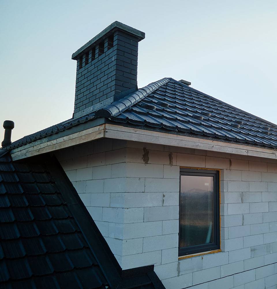 New house under construction with black ceramic shingles